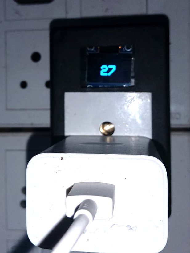 SmartCharge in use with a phone charger plugged in and a reading on its screen